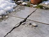 Joints de carrelage extérieur fissurés et craquelés après l'hiver à cause du gel et dégel