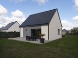 Maison contemporaine blanche à toit sombre, terrasse aménagée