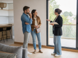 Agent immobilier présentant une maison à un couple